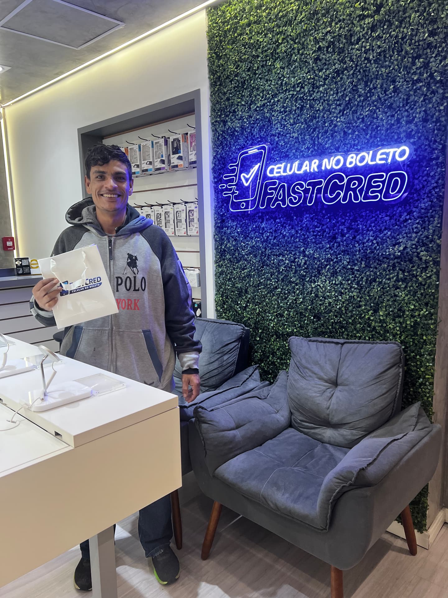 Cliente com sacola FastCred em frente ao letreiro da loja
